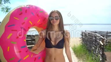 在阳光明媚的日子里，比基尼女孩带着洒满甜甜圈在游泳池里漂浮。 派对，酒店，海滩，度假，度假，旅行